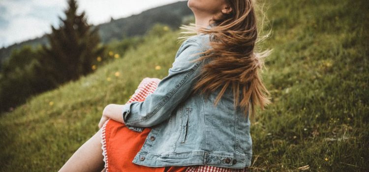 Woman enjoying leisure in a scenic meadow with a carefree vibe in Kitzbühel, Austria.